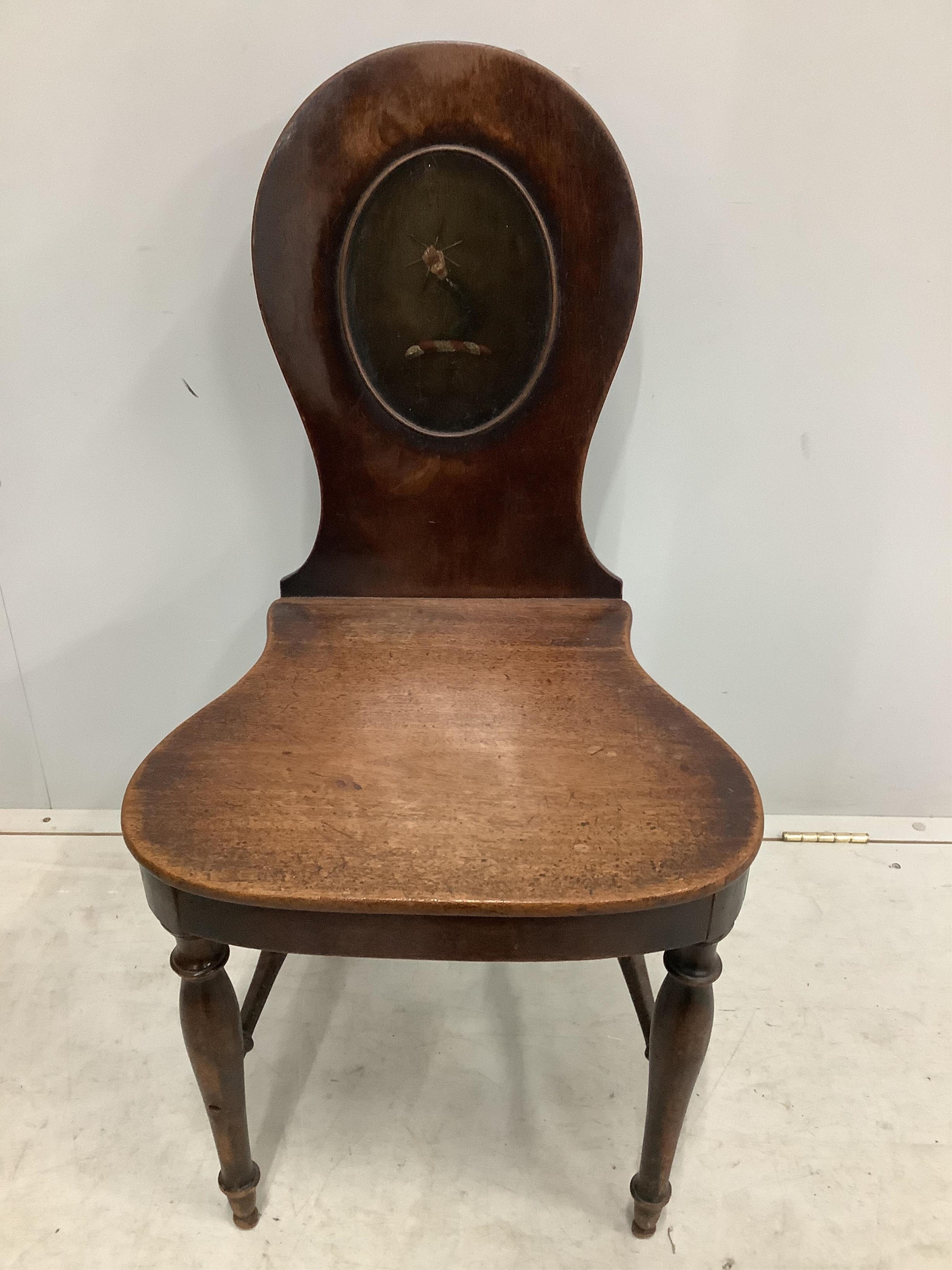 A pair of George III mahogany hall chairs with painted armorials, width 47cm, depth 42cm, height 92cm. Condition - fair